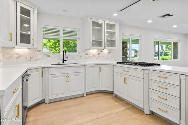 a kitchen with granite countertop white cabinets and stainless steel appliances