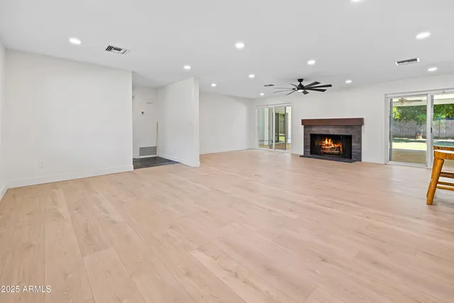 a view of an empty room with a fireplace and a window