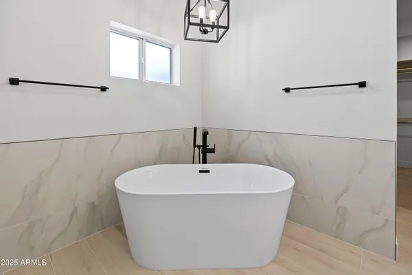 a bathroom with a tub sink shower and mirror
