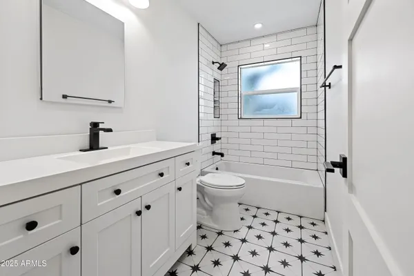 an empty room with windows and ceiling fan