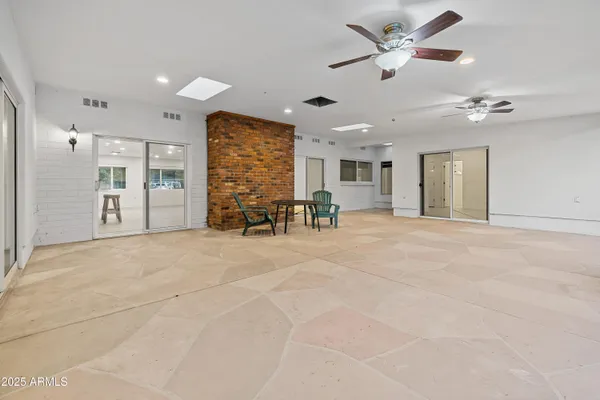 a view of a livingroom with a chandelier fan and wooden floor