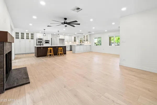 a large kitchen with kitchen island a sink a stove a dining table and chairs