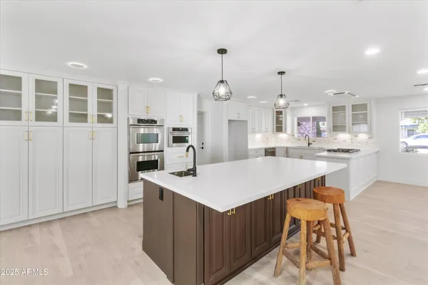 a kitchen with stainless steel appliances a sink stove and cabinets