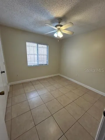 an empty room with a ceiling fan and carpet