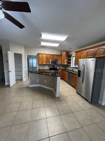 a kitchen with granite countertop a sink counter top space appliances and cabinets