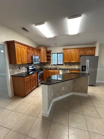 a view of an empty room and window chandelier fan