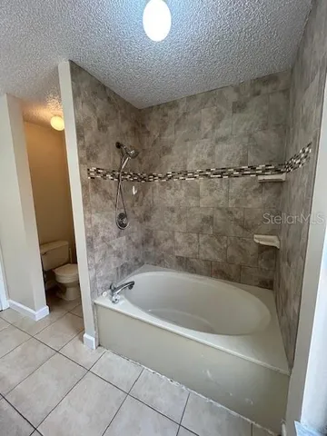 an empty room with windows and ceiling fan