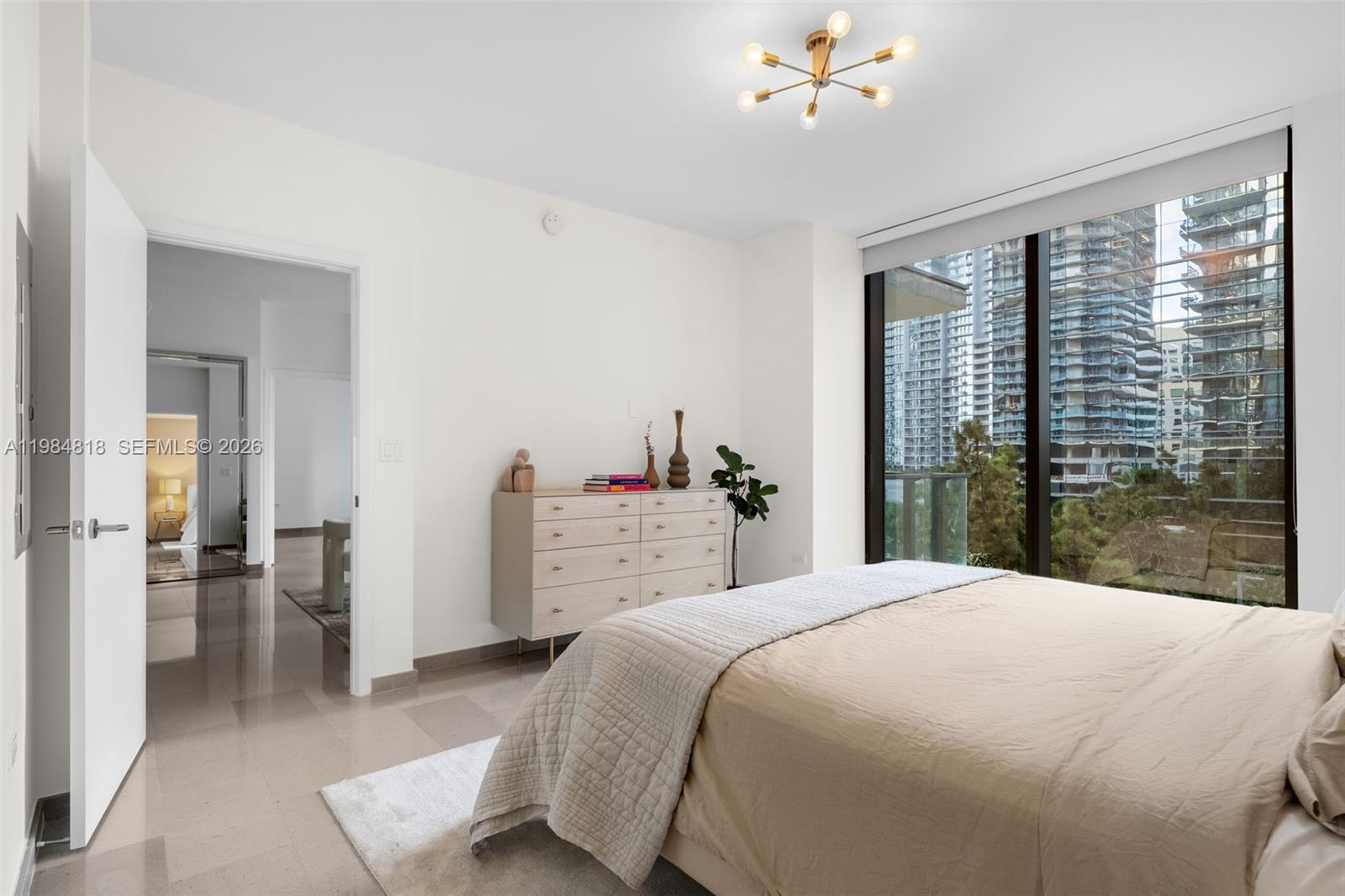 88 Southwest 7th Street, Unit 809 Miami, FL 33130 - Photo 12 of 39 a bedroom with a large bed and a chandelier