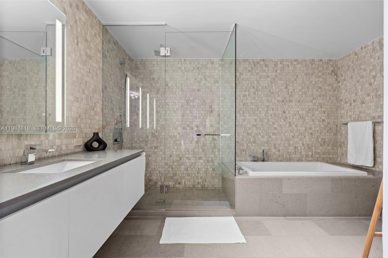 88 Southwest 7th Street, Unit 809 Miami, FL 33130 - Photo 16 of 39 a bathroom with a tub a sink and a shower