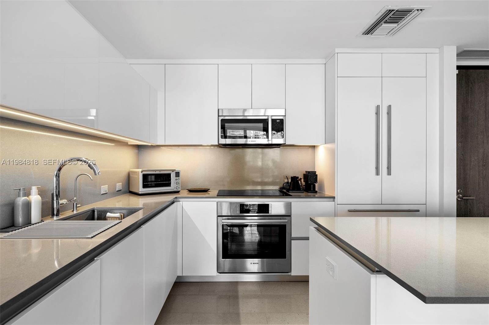 88 Southwest 7th Street, Unit 809 Miami, FL 33130 - Photo 17 of 39 a kitchen with stainless steel appliances granite countertop a sink stove and refrigerator