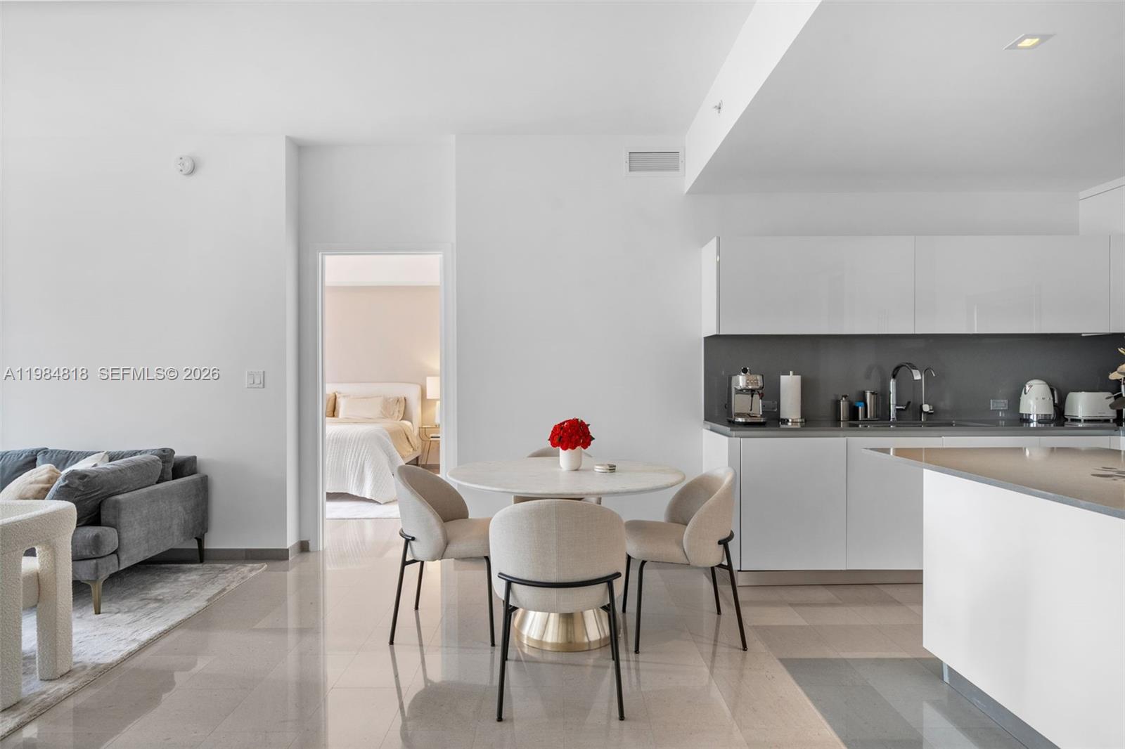 88 Southwest 7th Street, Unit 809 Miami, FL 33130 - Photo 4 of 39 a kitchen with stainless steel appliances kitchen island a table and chairs in it