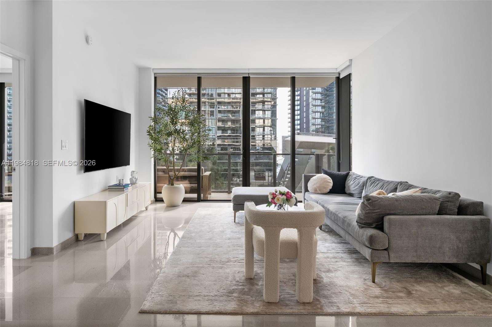 88 Southwest 7th Street, Unit 809 Miami, FL 33130 - Photo 5 of 39 a living room with furniture and a flat screen tv