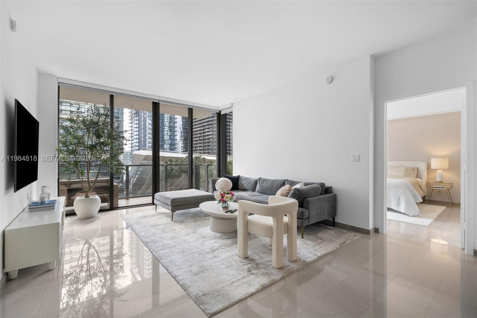88 Southwest 7th Street, Unit 809 Miami, FL 33130 - Photo 6 of 39 a living room with furniture large window and a flat screen tv