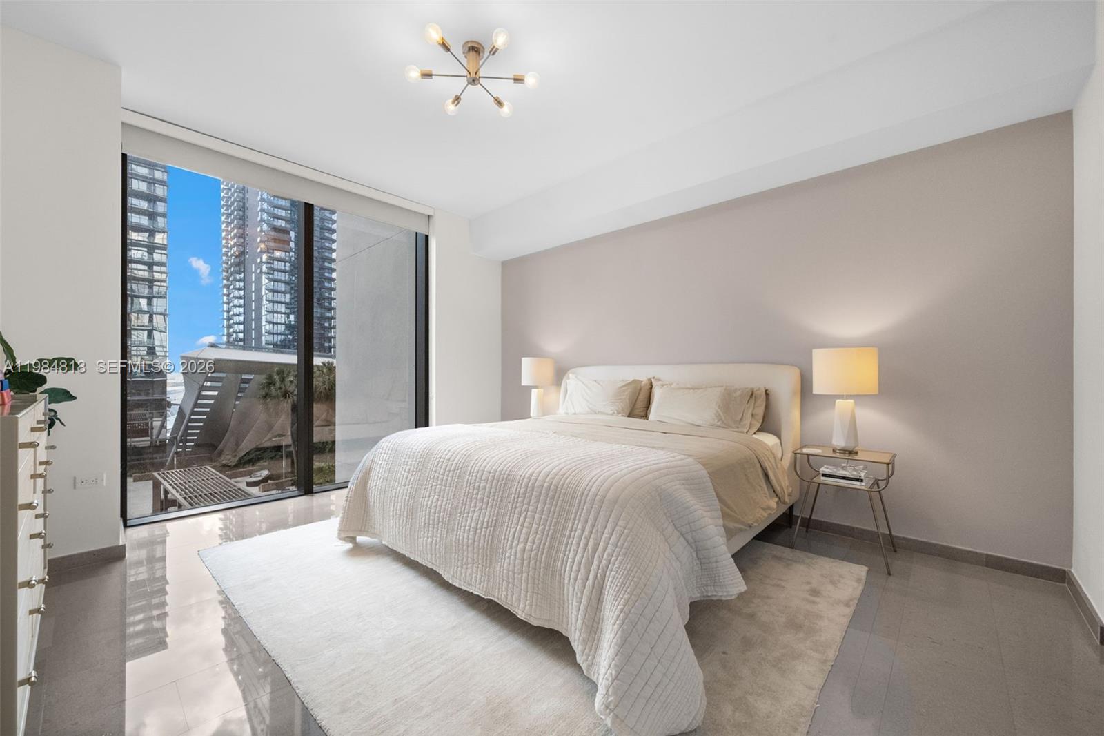 88 Southwest 7th Street, Unit 809 Miami, FL 33130 - Photo 10 of 39 a bedroom with a large bed and a chandelier