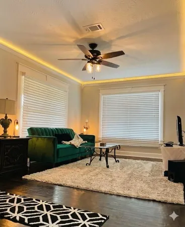 a living room with stainless steel appliances furniture and a rug