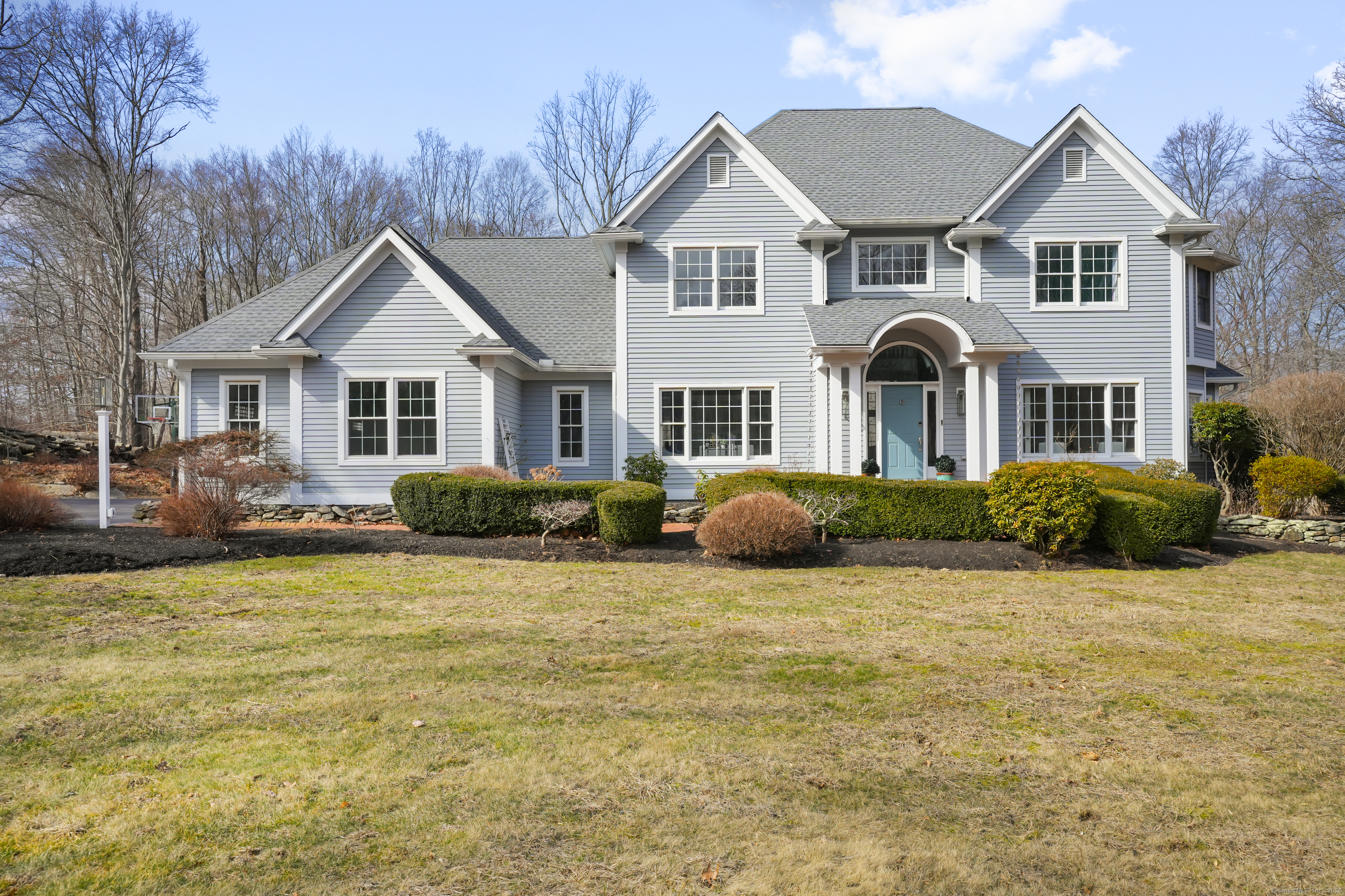 a view of a house with a big yard and large trees