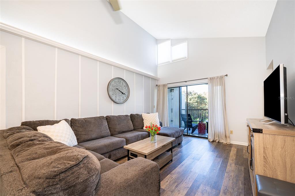 3916 Atrium Drive, Unit 4 Orlando, FL 32822 - Photo 11 of 71 a living room with furniture a large window and a flat screen tv