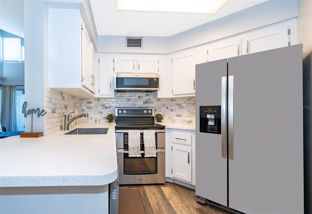 3916 Atrium Drive, Unit 4 Orlando, FL 32822 - Photo 16 of 71 a kitchen with stainless steel appliances a refrigerator stove and sink