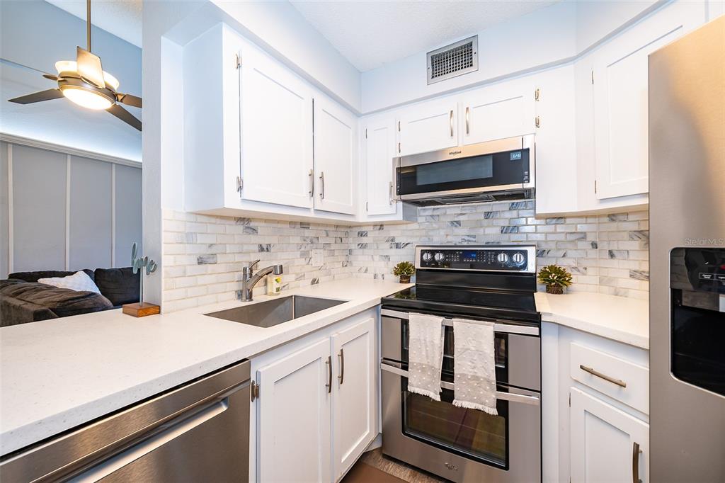 3916 Atrium Drive, Unit 4 Orlando, FL 32822 - Photo 17 of 71 a kitchen with a sink stove and microwave