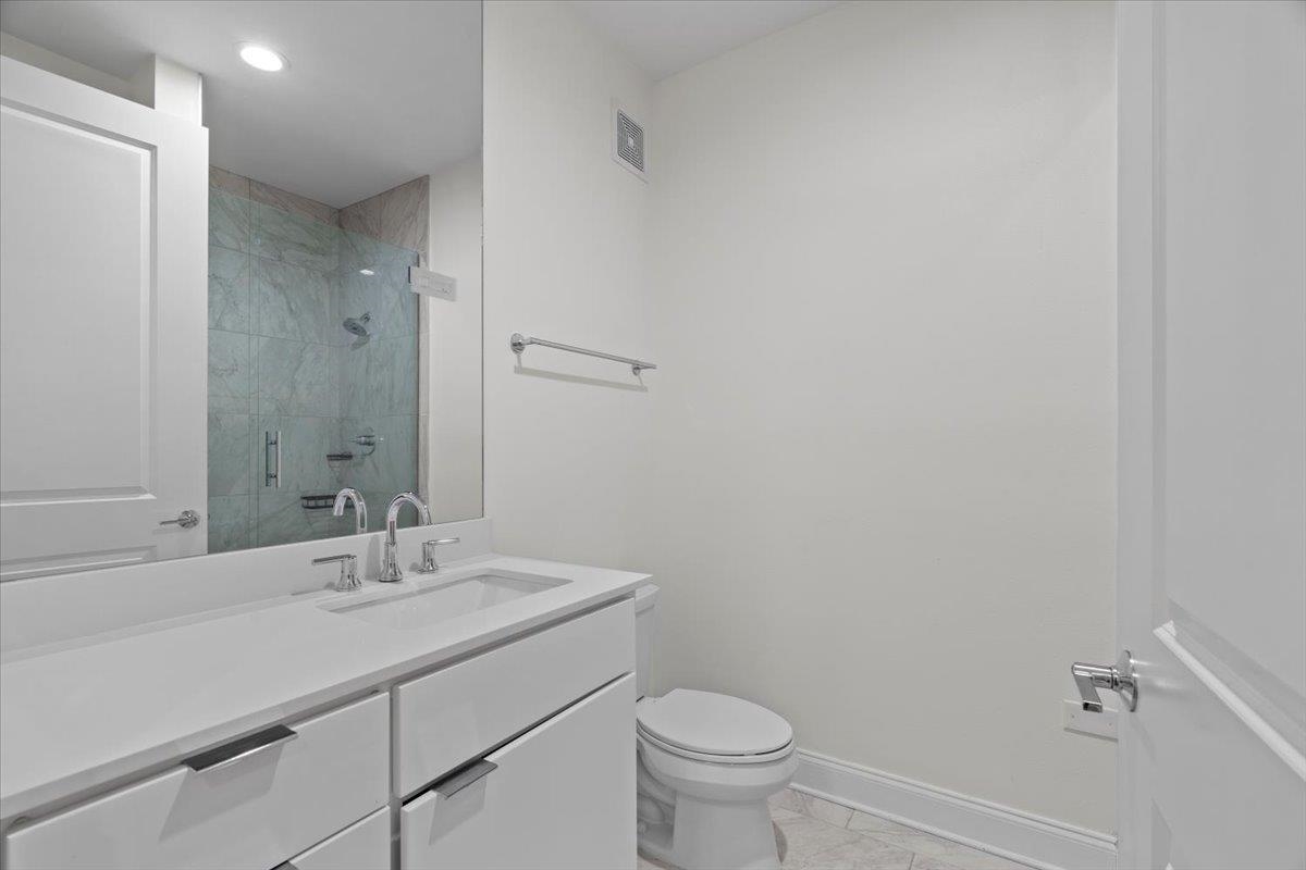 717 Riverside Drive, Unit 906 Memphis, TN 38103 - Photo 15 of 24 Full bath with vanity, visible vents, toilet, a stall shower, and baseboards