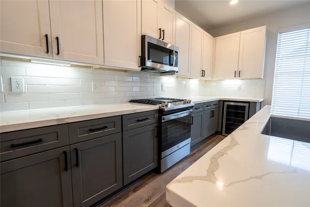 a kitchen with stainless steel appliances a stove microwave and sink
