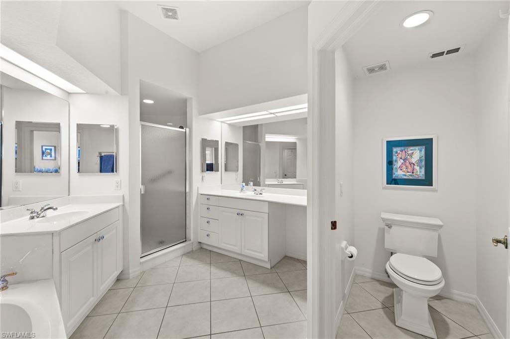 10205 Cape Roman Road Bonita Springs, FL 34135 - Photo 12 of 31 a spacious bathroom with a toilet sink shower and mirror