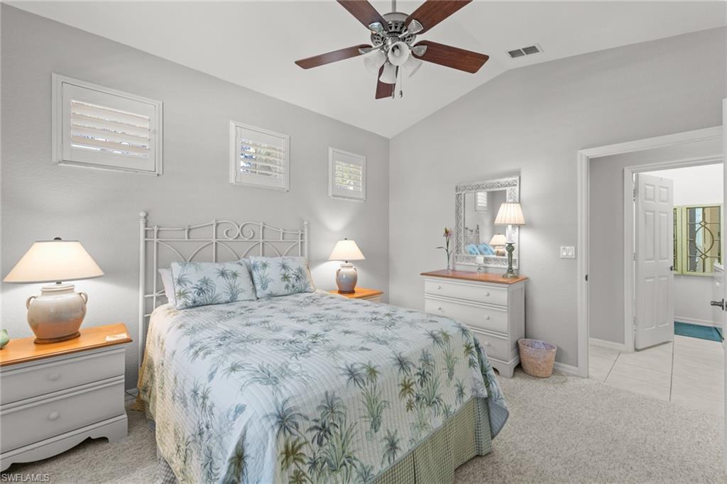 10205 Cape Roman Road Bonita Springs, FL 34135 - Photo 13 of 31 a bedroom with a bed and a chandelier