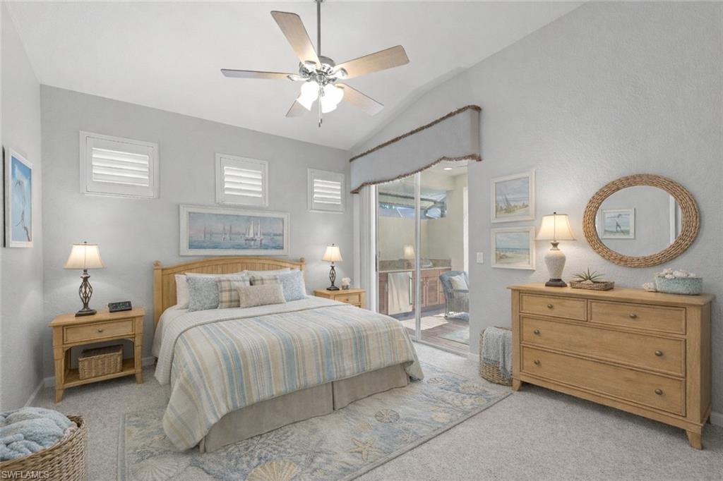 10205 Cape Roman Road Bonita Springs, FL 34135 - Photo 16 of 31 a bedroom with a bed a mirror on dresser and a chandelier