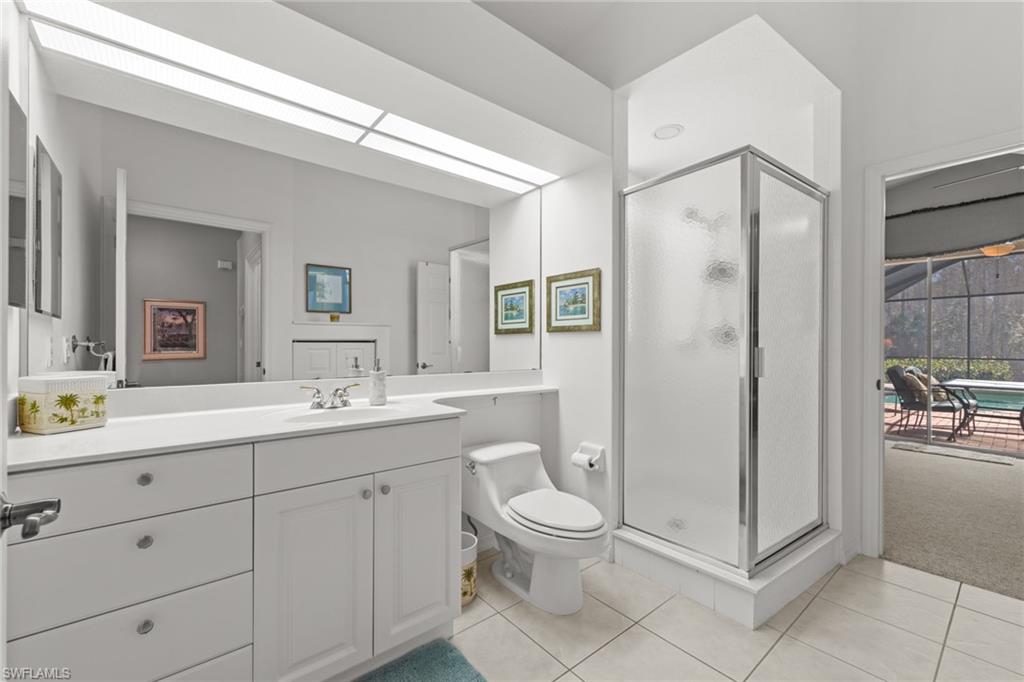 10205 Cape Roman Road Bonita Springs, FL 34135 - Photo 18 of 31 a spacious bathroom with a toilet a sink a mirror and a shower