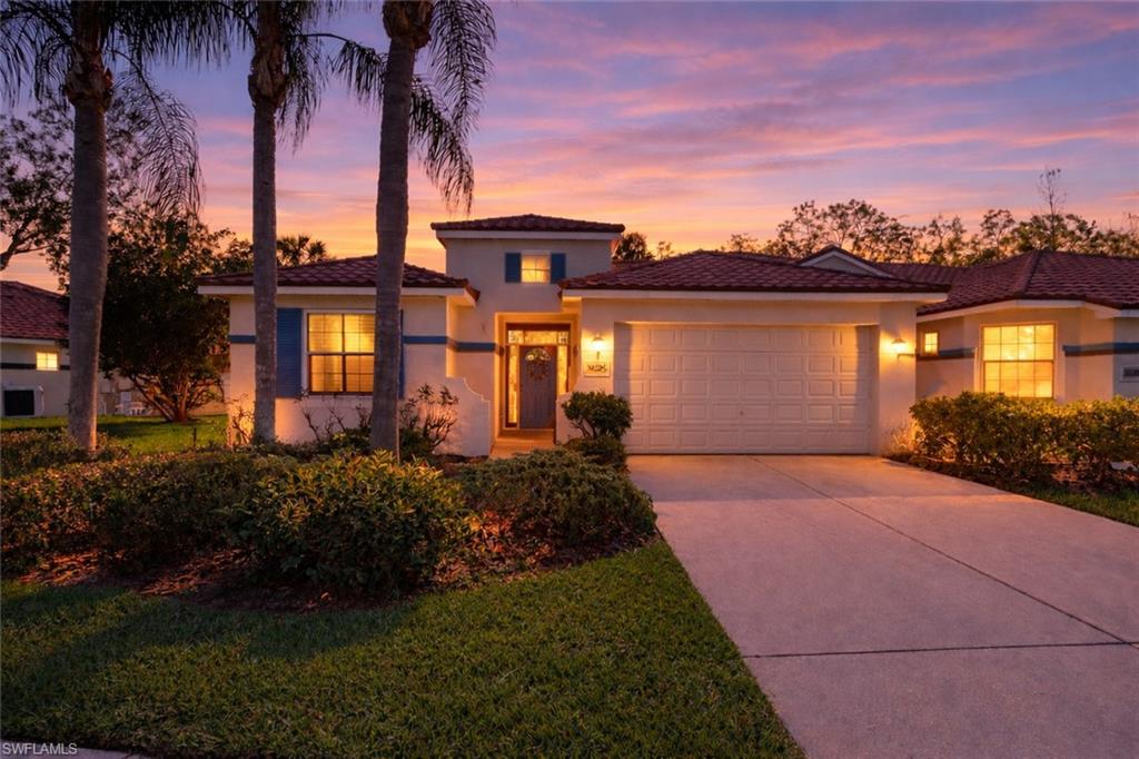 10205 Cape Roman Road Bonita Springs, FL 34135 - Photo 2 of 31 a front view of a house with a garden and a yard