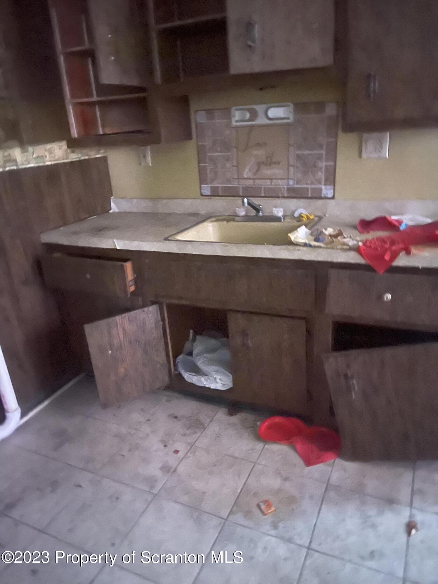 831 Monroe Avenue Scranton, PA 18510 - Photo 24 of 35 a kitchen with a sink and a wooden cabinets