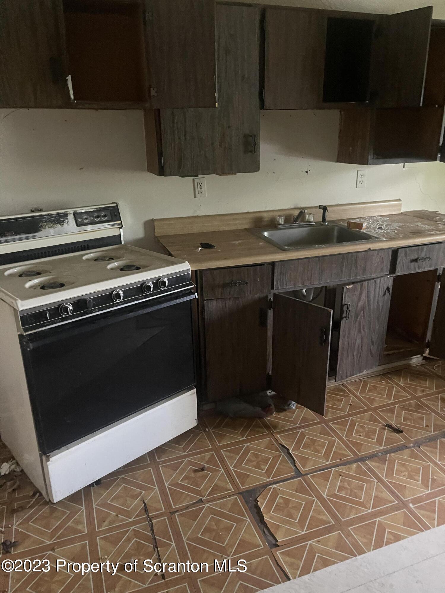 831 Monroe Avenue Scranton, PA 18510 - Photo 4 of 35 a kitchen with a stove a sink and a microwave