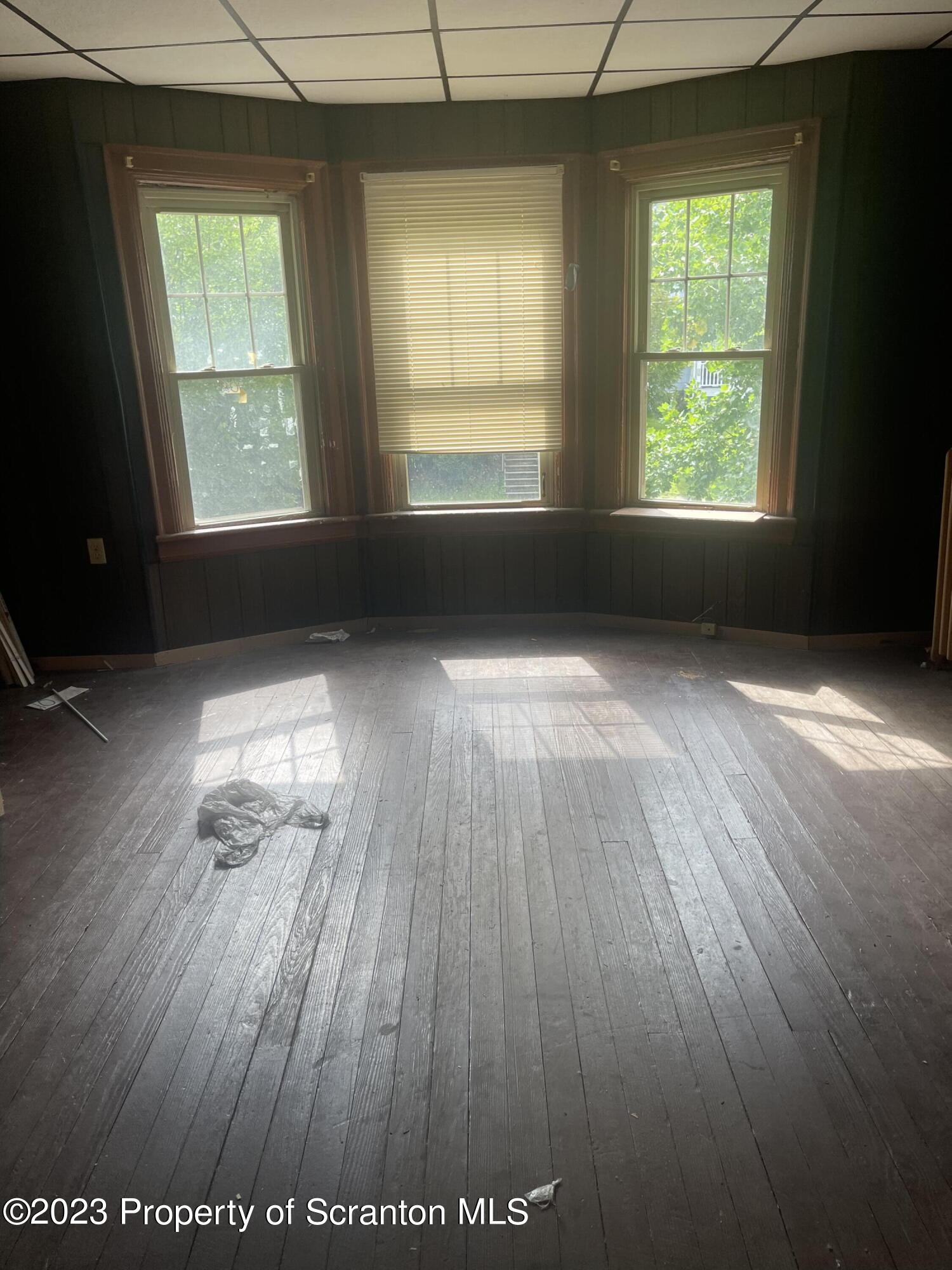 831 Monroe Avenue Scranton, PA 18510 - Photo 10 of 35 an empty room with wooden floor and windows