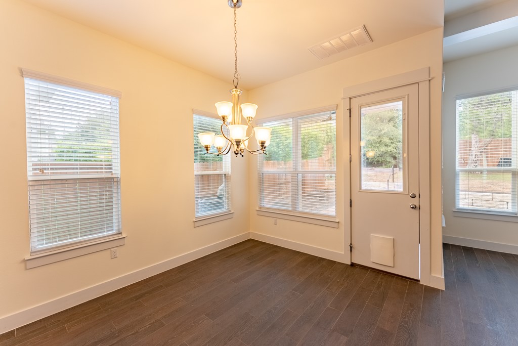 13008 Armaga Springs Road Austin, TX 78727 - Photo 11 of 33 Unfurnished dining area featuring a chandelier and dark wood-type flooring