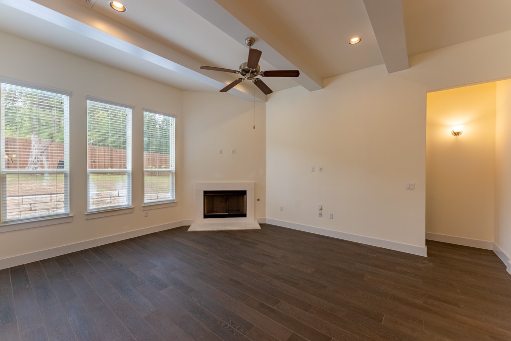13008 Armaga Springs Road Austin, TX 78727 - Photo 13 of 33 Unfurnished living room with ceiling fan, recessed lighting, a fireplace, dark wood-style floors, and beamed ceiling
