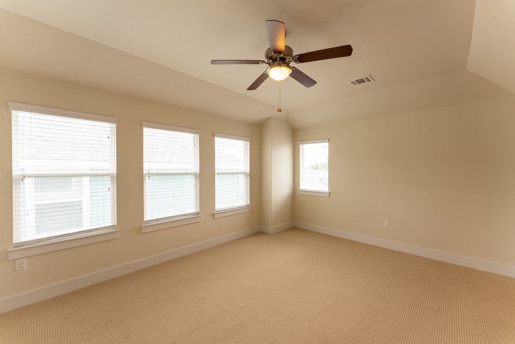 13008 Armaga Springs Road Austin, TX 78727 - Photo 21 of 33 Empty room featuring carpet, a ceiling fan, and lofted ceiling