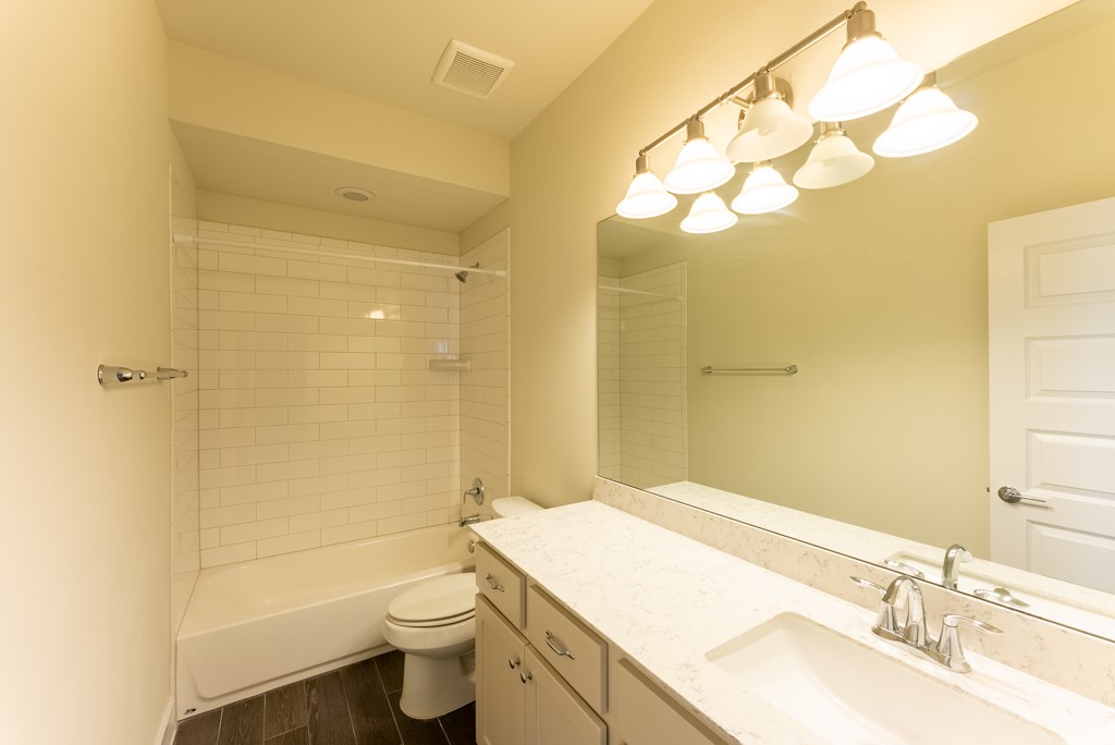 13008 Armaga Springs Road Austin, TX 78727 - Photo 26 of 33 Full bathroom with vanity, shower combination, and dark wood-type flooring