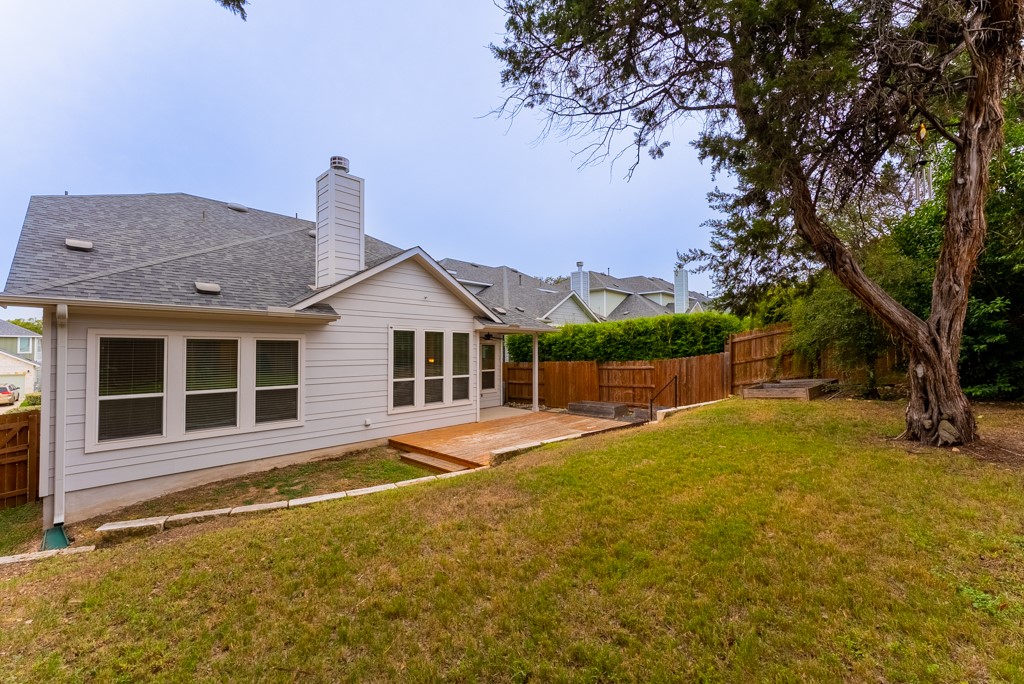 13008 Armaga Springs Road Austin, TX 78727 - Photo 31 of 33 Rear view of property featuring a wooden deck, a chimney, a fenced backyard, and a shingled roof