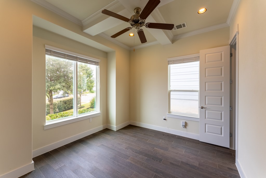13008 Armaga Springs Road Austin, TX 78727 - Photo 6 of 33 Spare room featuring dark wood-style flooring, recessed lighting, ceiling fan, ornamental molding, and plenty of natural light