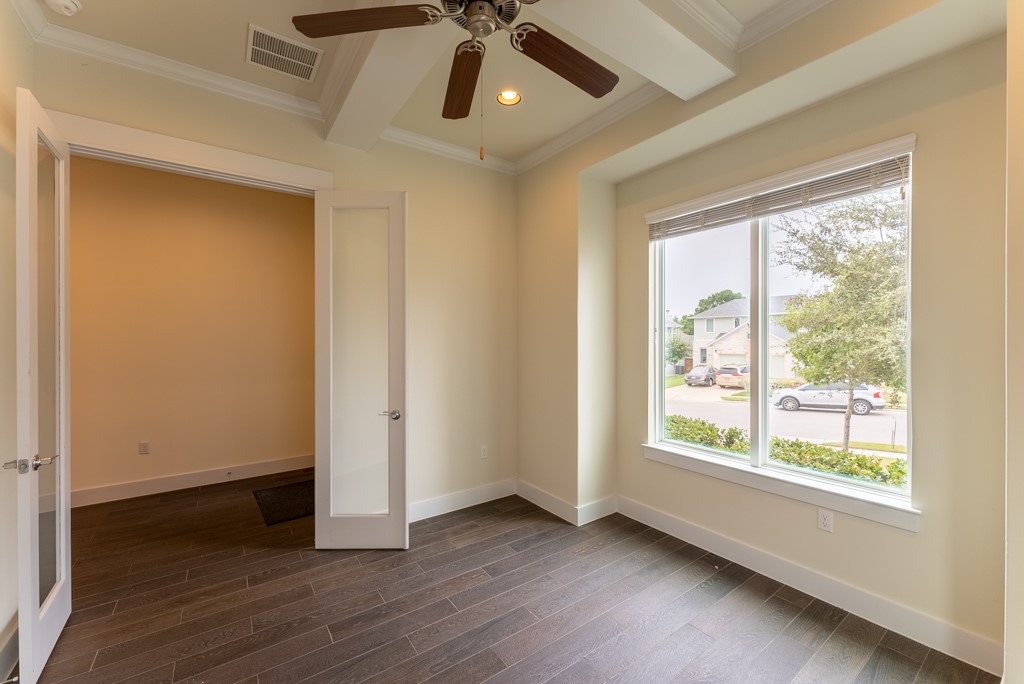 13008 Armaga Springs Road Austin, TX 78727 - Photo 7 of 33 Unfurnished room featuring recessed lighting, ceiling fan, dark wood finished floors, crown molding, and beamed ceiling