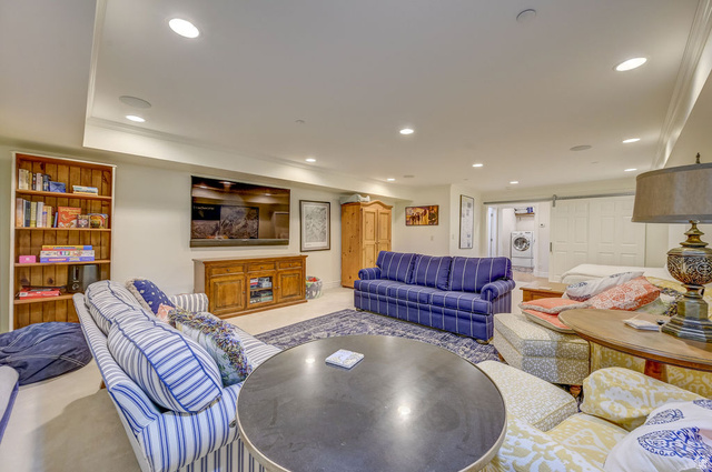 9699 Bypass Road, Unit 5 Alta, UT 84092 - Photo 10 of 54 Spacious entertainment room featuring recessed lighting, crown molding, a built-in wood bookshelf, and barn door access to a laundry area with a visible washer and dryer