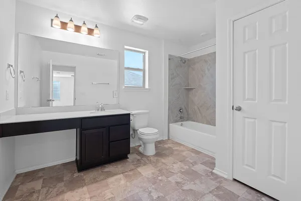 a bathroom with a double vanity sink a toilet and a bathtub