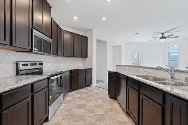 a kitchen with granite countertop stainless steel appliances and sink
