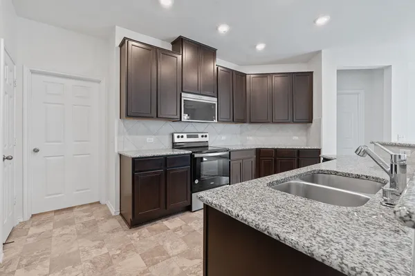 a kitchen with stainless steel appliances granite countertop a sink stove and refrigerator