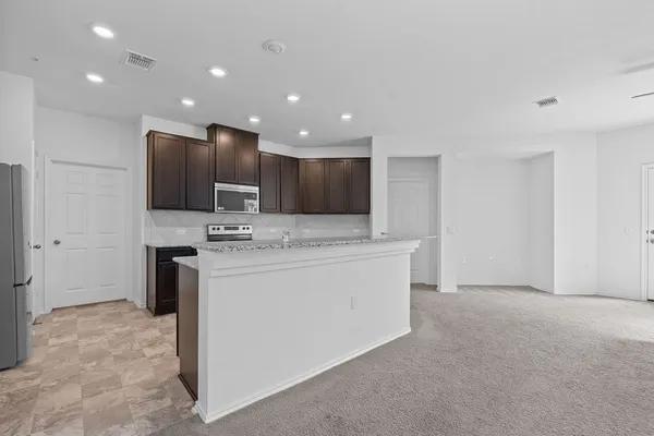 a view of a kitchen with stainless steel appliances granite countertop cabinets and a refrigerator