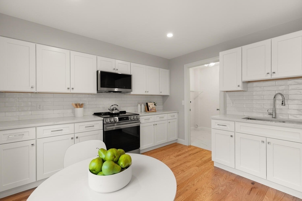 1 Barracks Road, Unit 1 Hudson, MA 01749 - Photo 2 of 29 a kitchen with stainless steel appliances kitchen island granite countertop a sink a stove a microwave and cabinets
