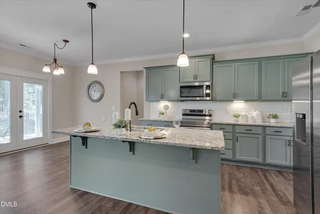 a kitchen with stainless steel appliances granite countertop a sink refrigerator and microwave