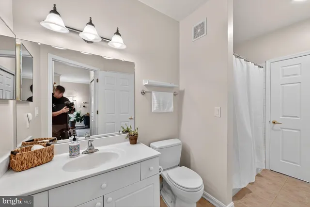 a bathroom with a sink vanity granite and toilet