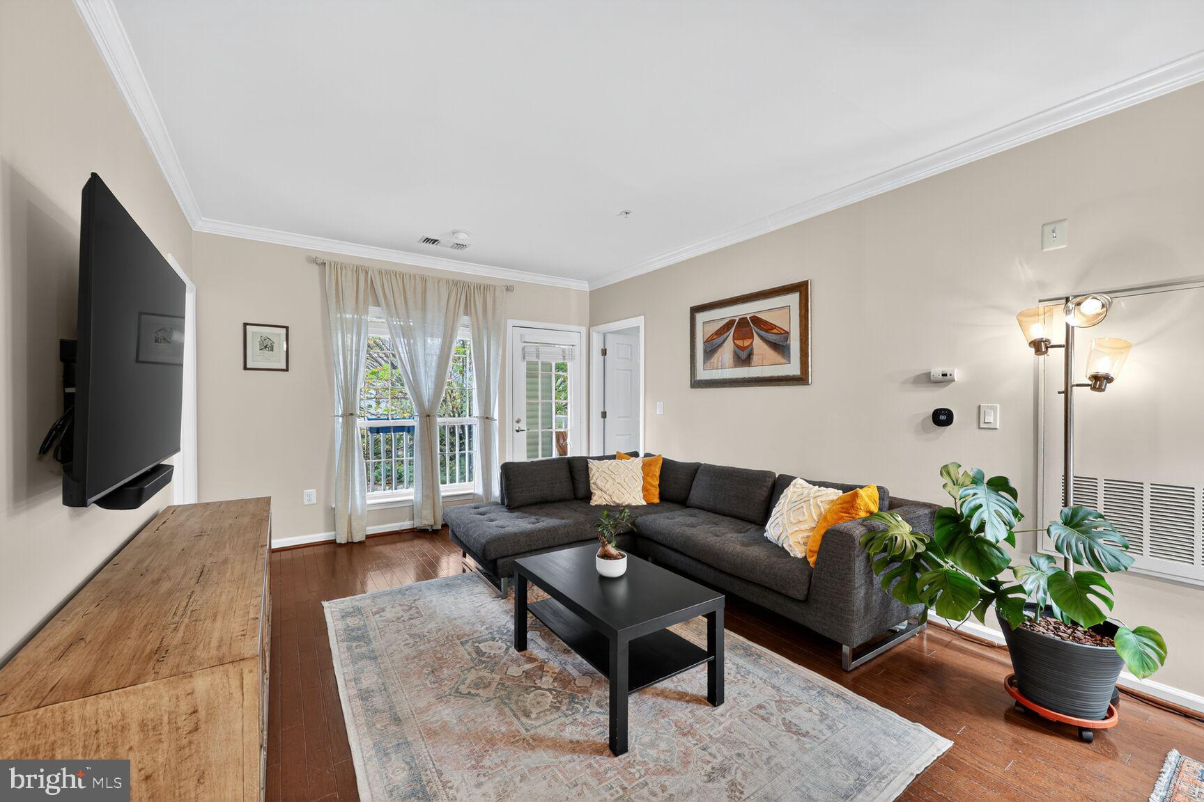 4561 Strutfield Lane, Unit 3211 Alexandria, VA 22311 - Photo 2 of 14 a living room with furniture potted plant and a flat screen tv