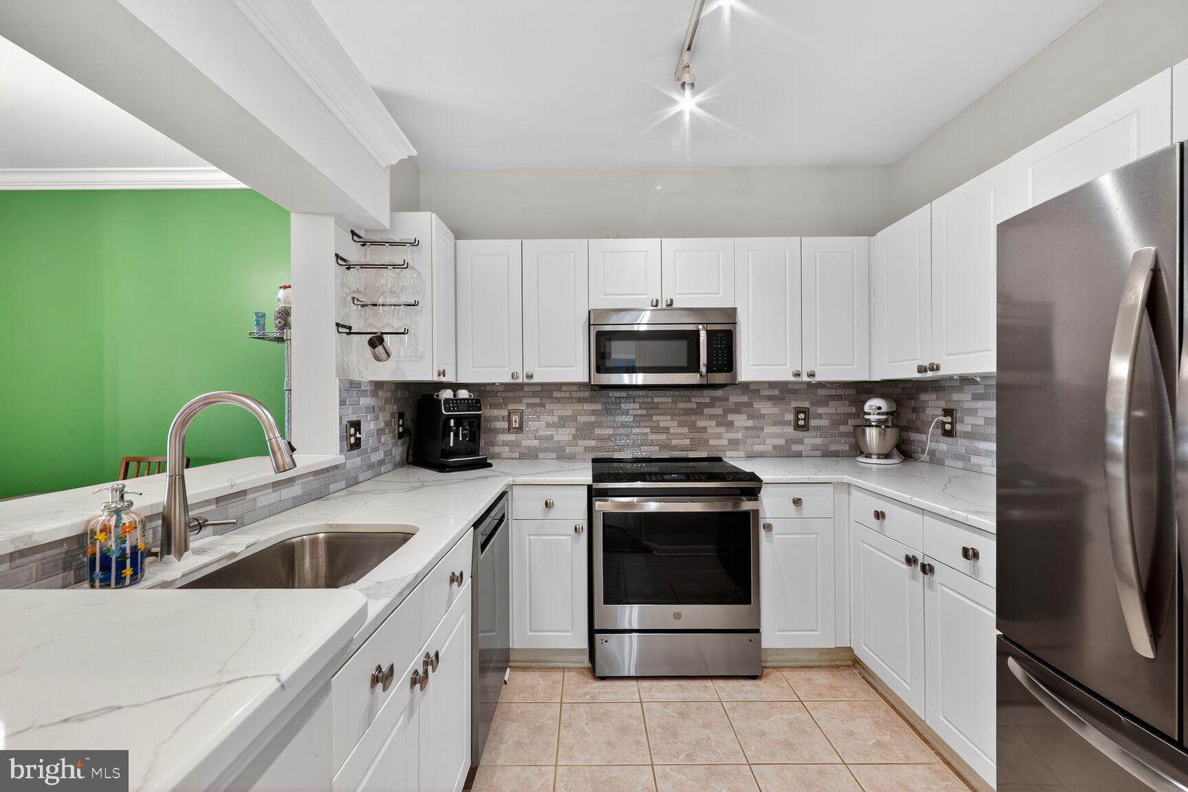 4561 Strutfield Lane, Unit 3211 Alexandria, VA 22311 - Photo 7 of 14 a kitchen with a sink a stove and refrigerator